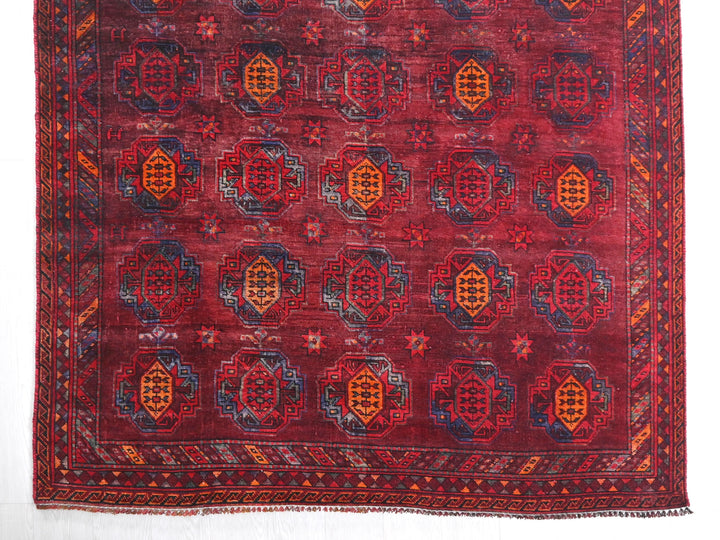 a red rug with a design on the middle of it