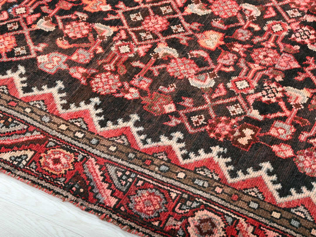 a red and black oriental rug on a white floor