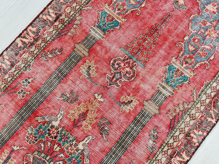 a red oriental rug on a white wooden floor