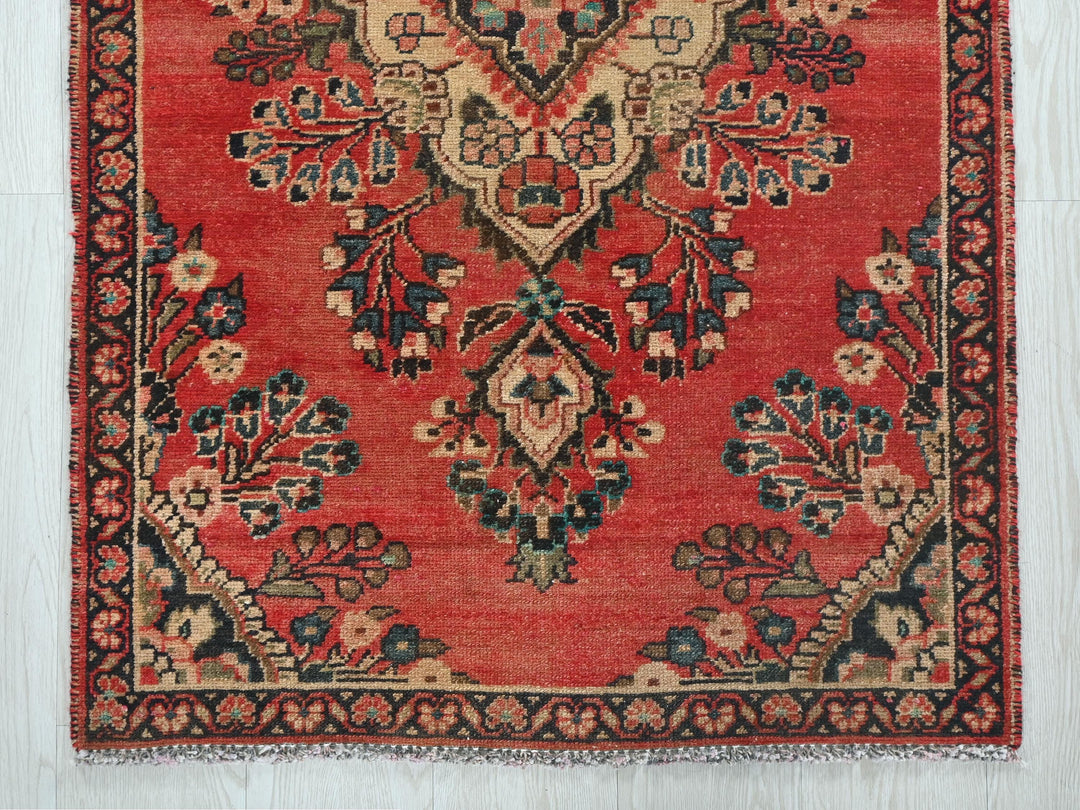 a red rug with a floral design on it