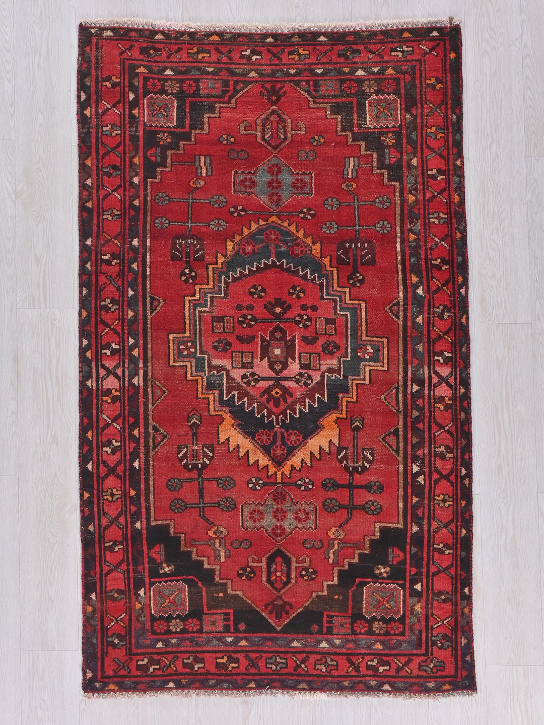 a red rug with a design on the middle of it