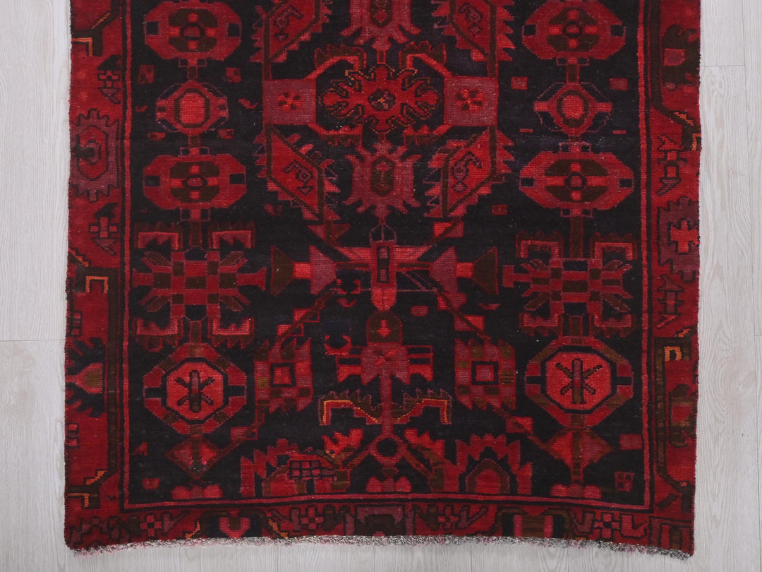a red and black rug with a design on it