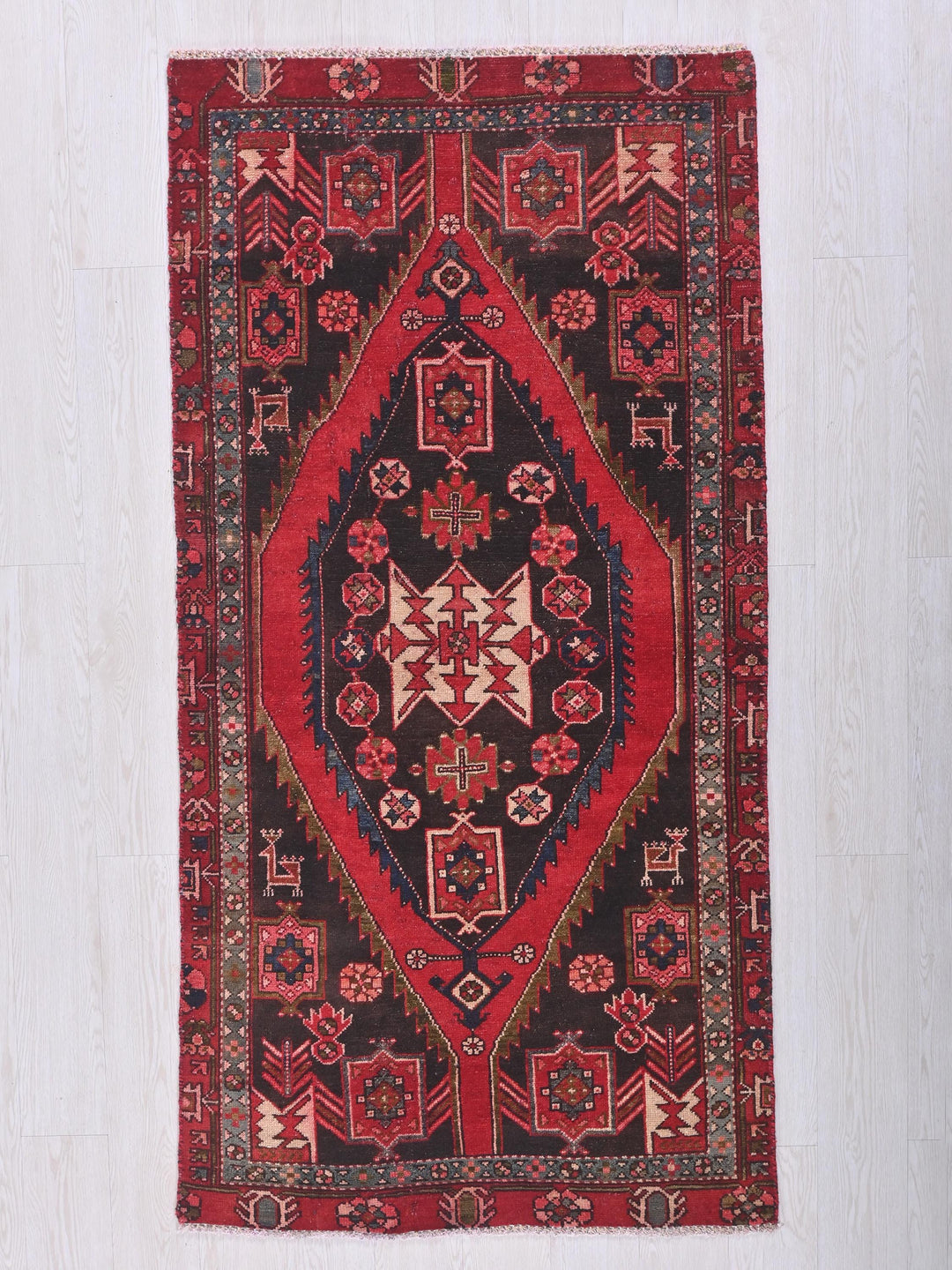 a red and black oriental rug hanging on a wall