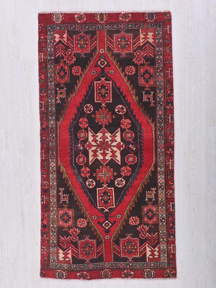 a red and black oriental rug hanging on a wall