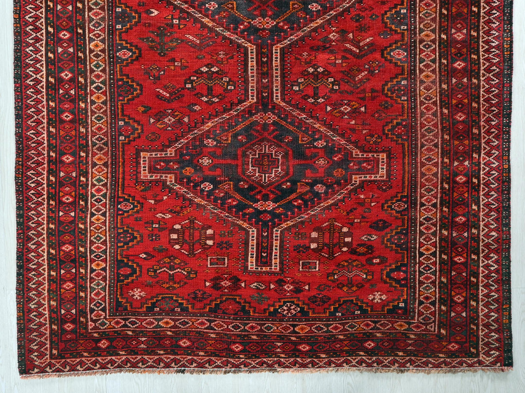 a red rug with a design on it