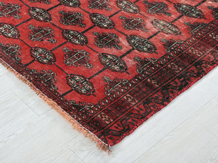 a red and black rug on a white floor
