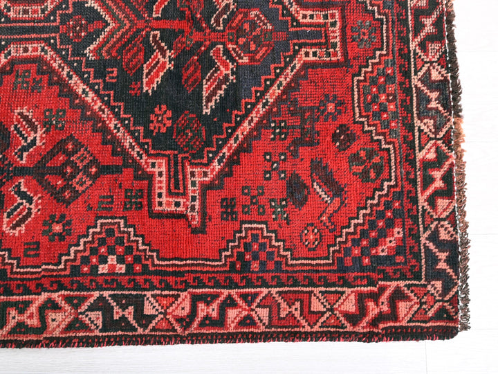 a red and black oriental rug on a white background