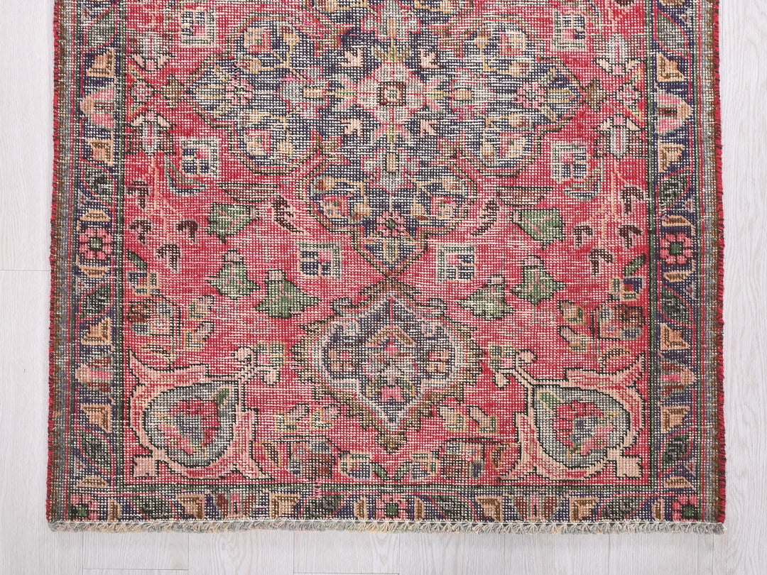 a red rug with a floral design on it