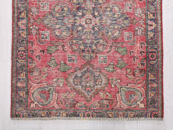 a red rug with a floral design on it