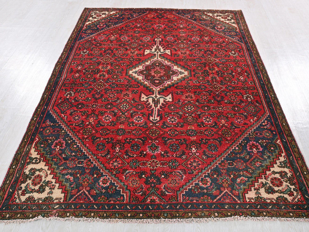 a red rug with a diamond shaped design on it