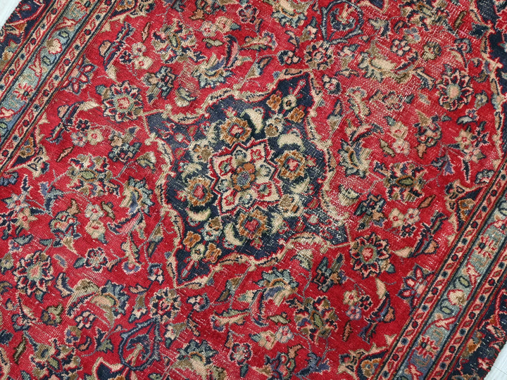 a red rug with a floral design on it
