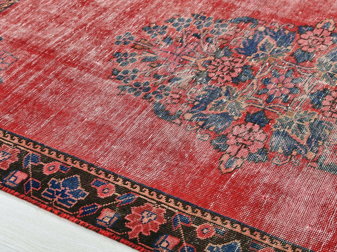 a red rug with a floral design on it