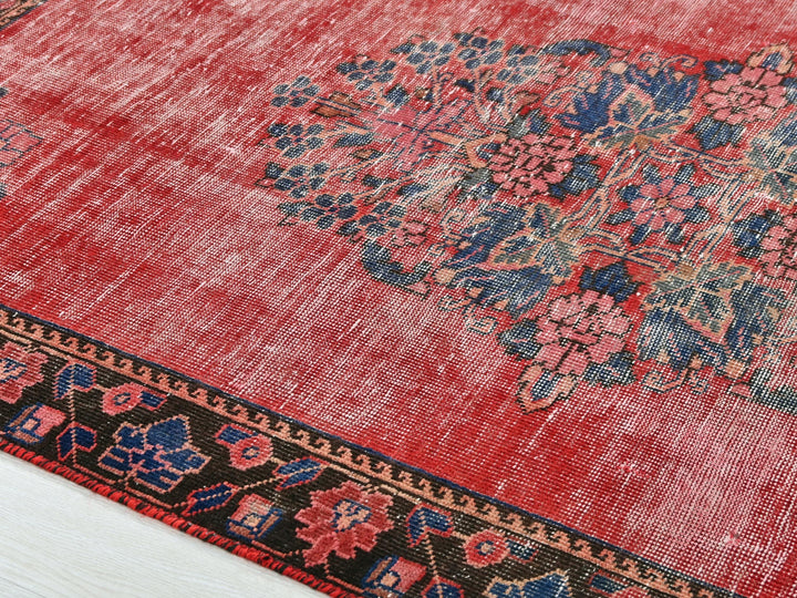 a red rug with a floral design on it