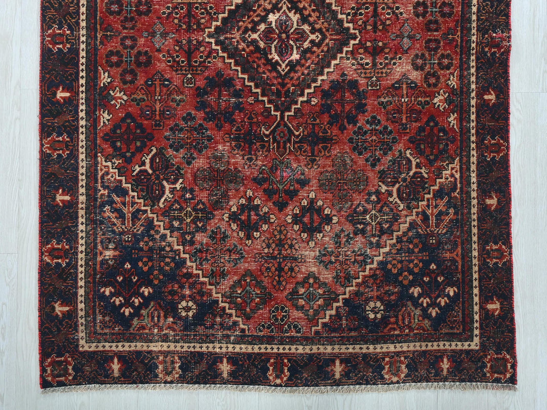 a red and black rug on a white floor