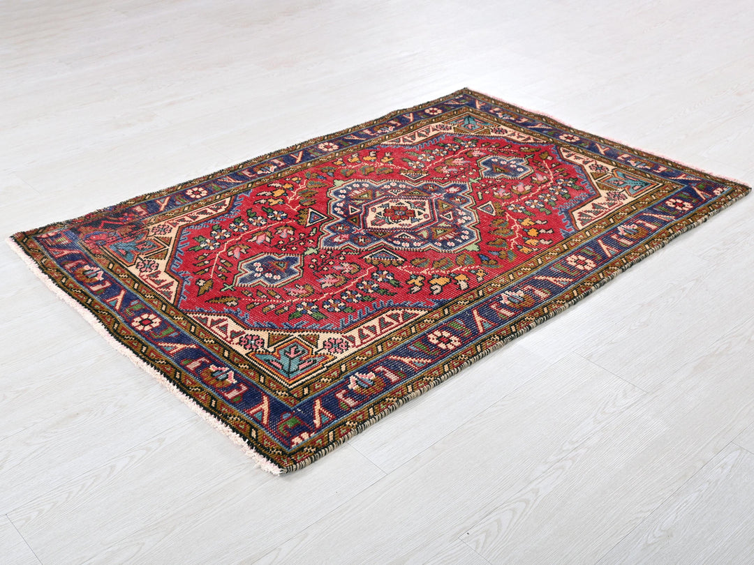 a red and blue rug on a white floor