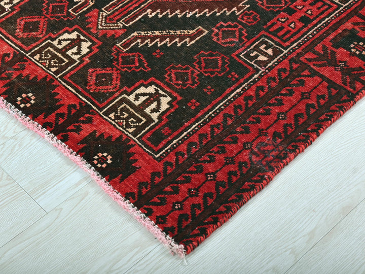 a red and black rug on a white floor
