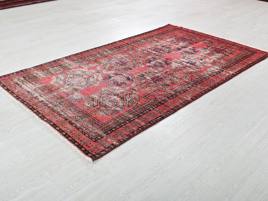 a red oriental rug on a white floor