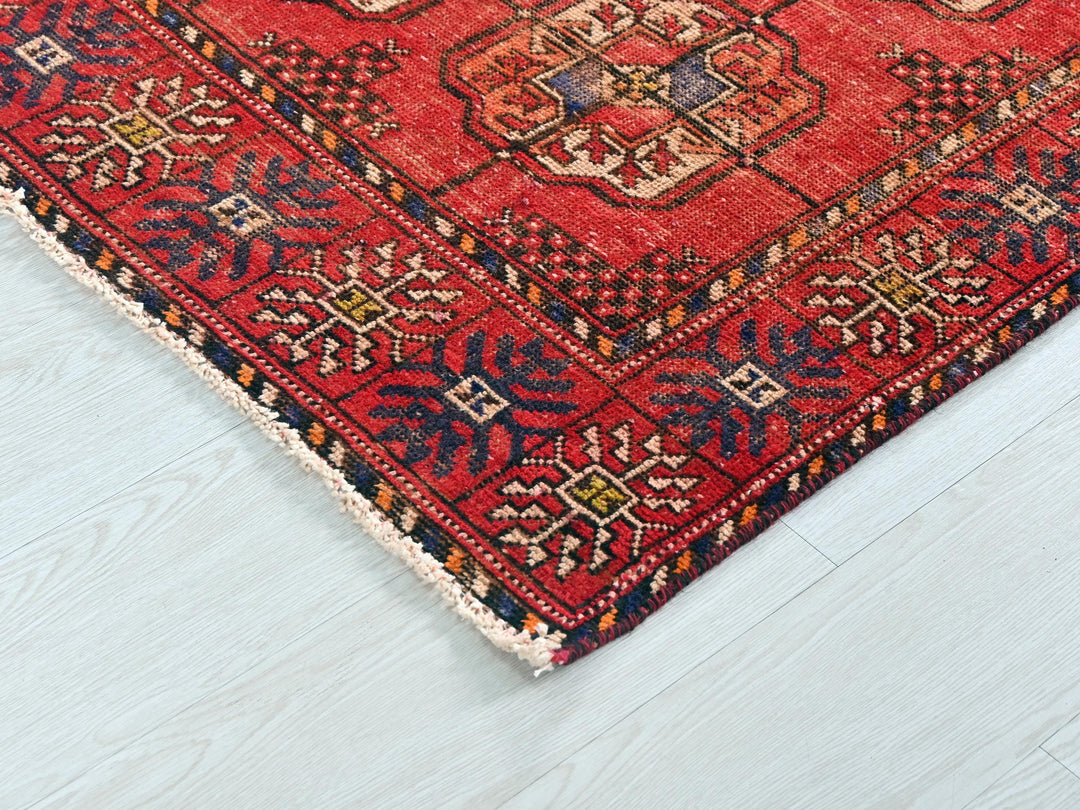 a red rug on a white wooden floor