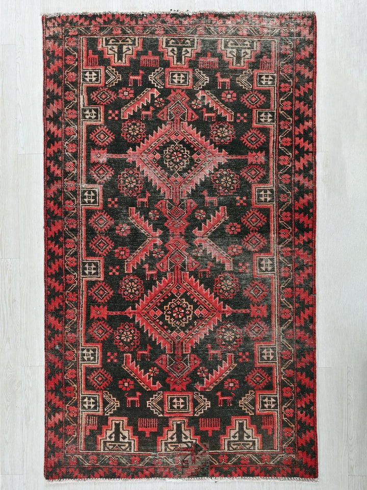a red and black oriental rug on a white wall