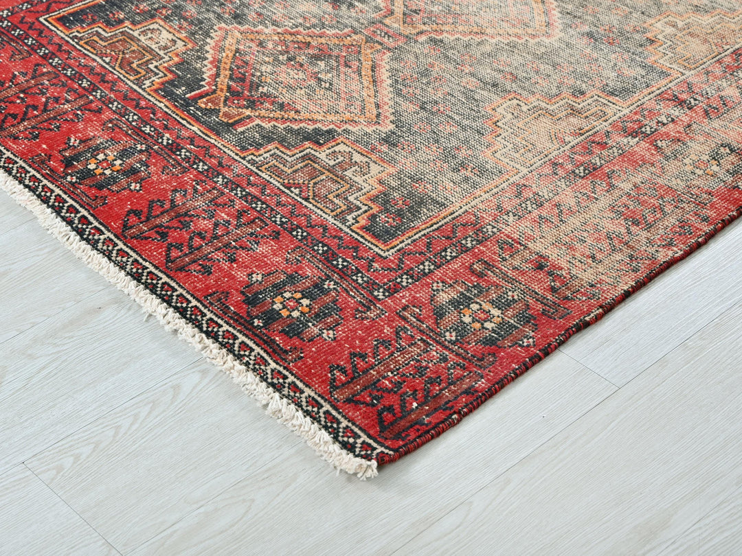 a red and black oriental rug on a white floor