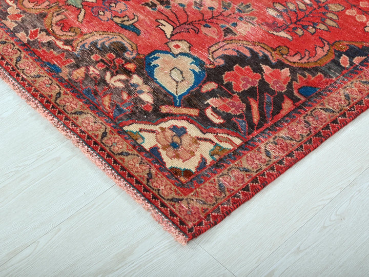 a red oriental rug on a white wooden floor
