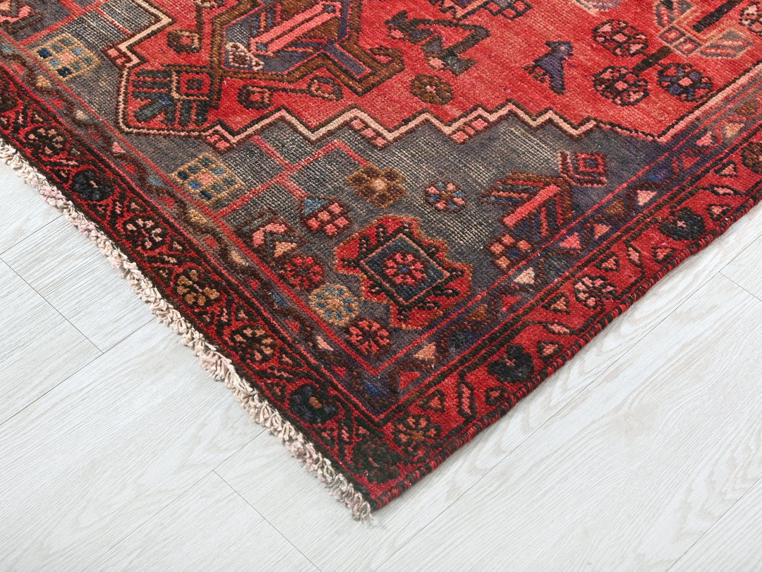 a red oriental rug on a white wooden floor