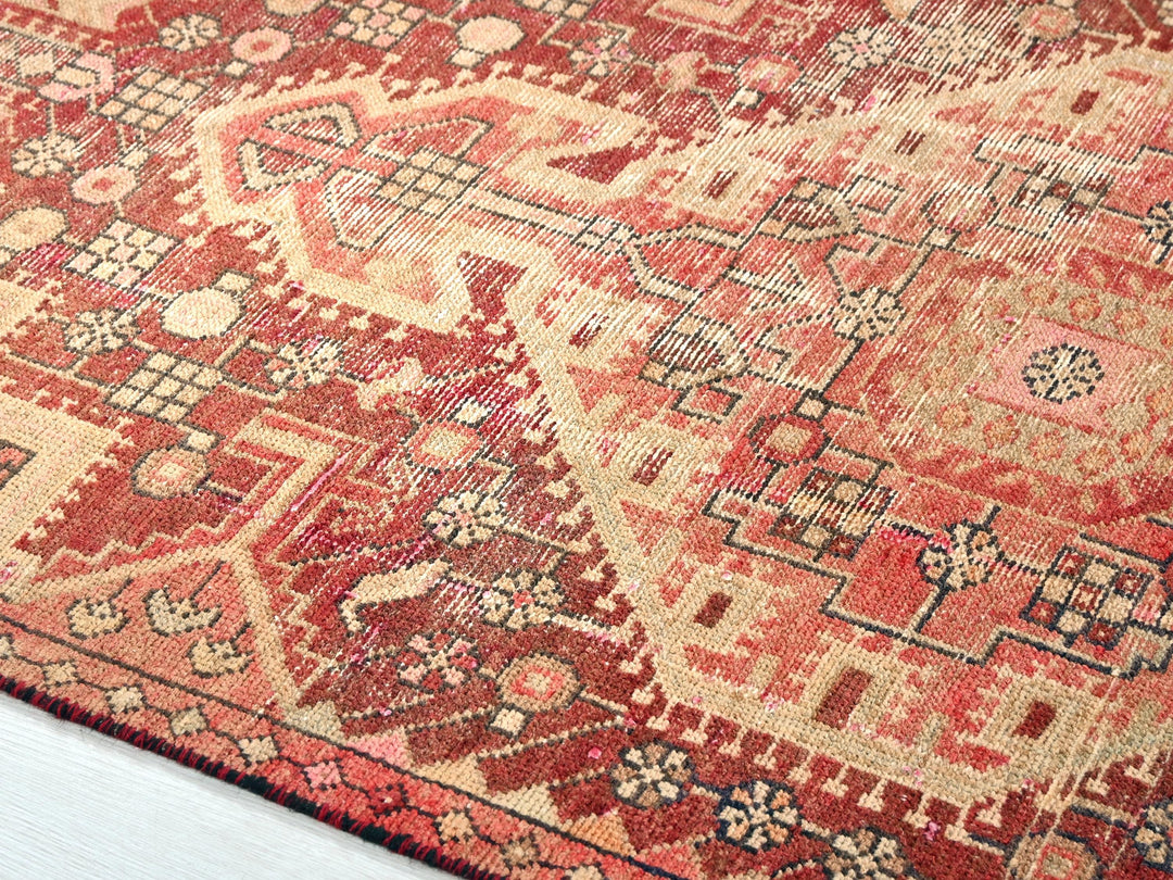 a red and beige oriental rug on a white floor