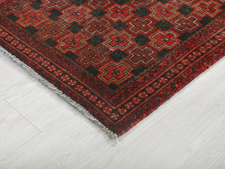 a red and black rug on a white floor