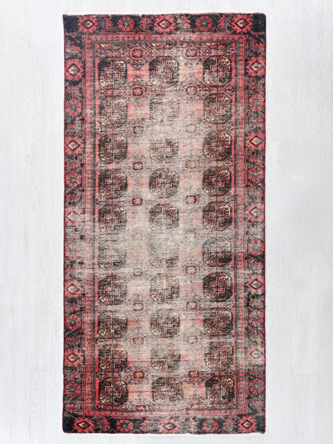 a red and black rug on a white wall
