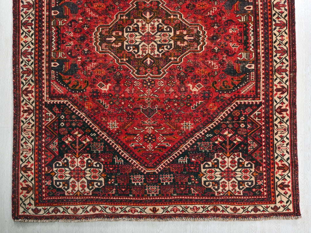 a red and black oriental rug on a white wall
