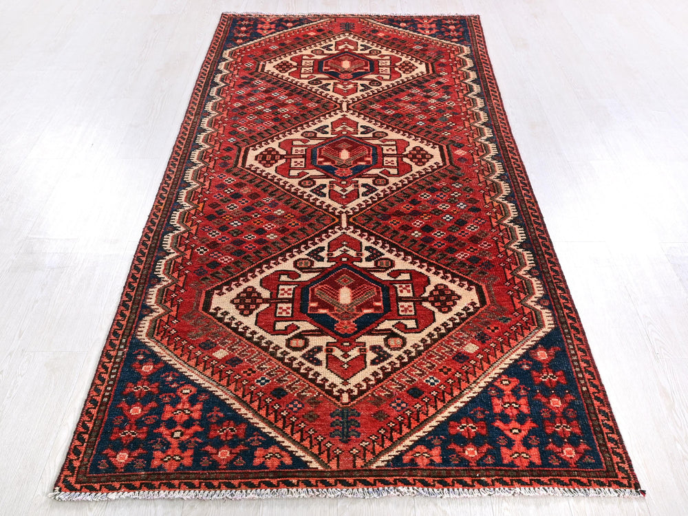 a red and blue rug on a white floor