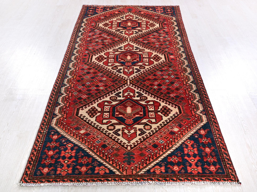a red and blue rug on a white floor
