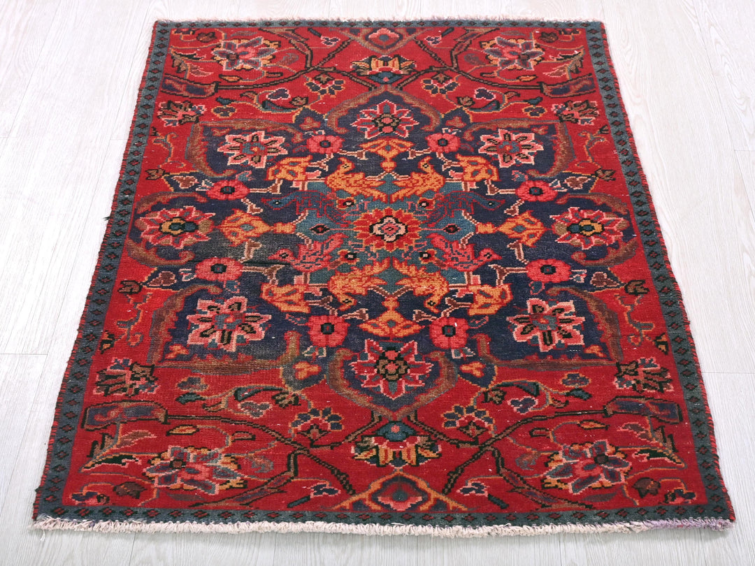 a red and blue rug on a white floor