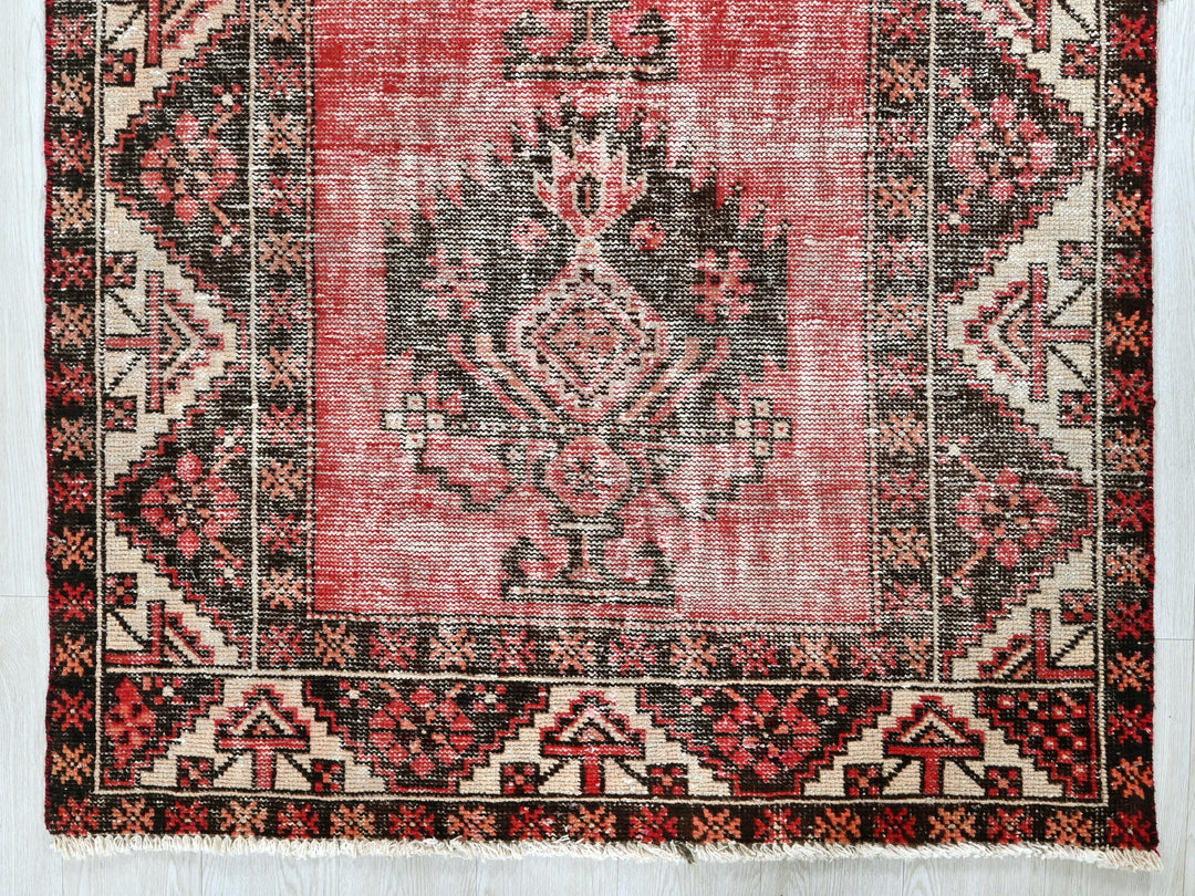 a red and black rug with a design on it