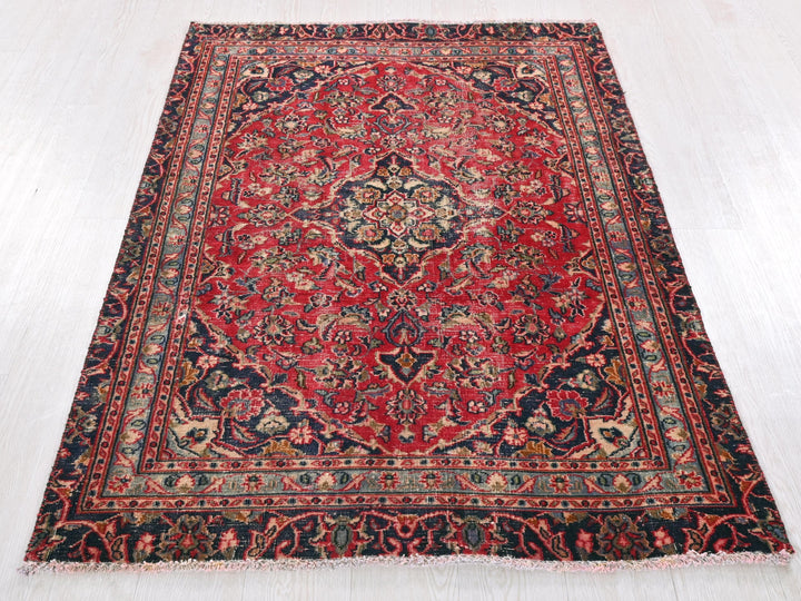 a red and blue rug on a white floor