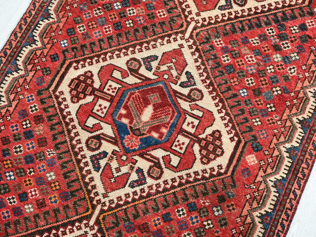 a red and blue rug on a wooden floor