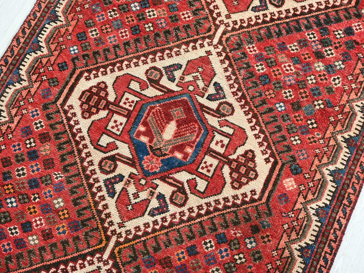 a red and blue rug on a wooden floor