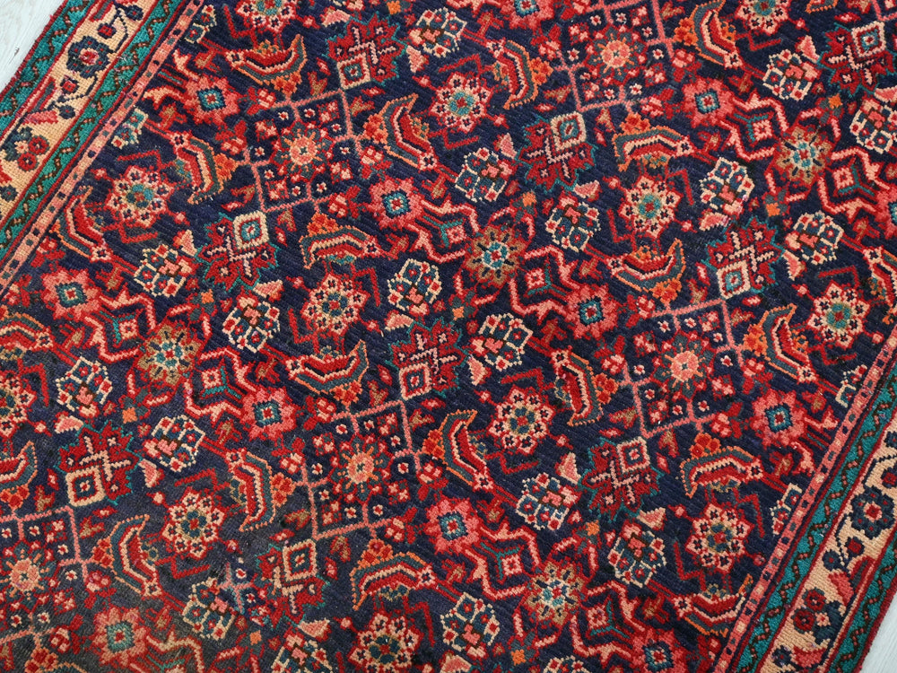 a red and blue oriental rug on a white floor