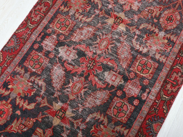 a red and black oriental rug on a white floor