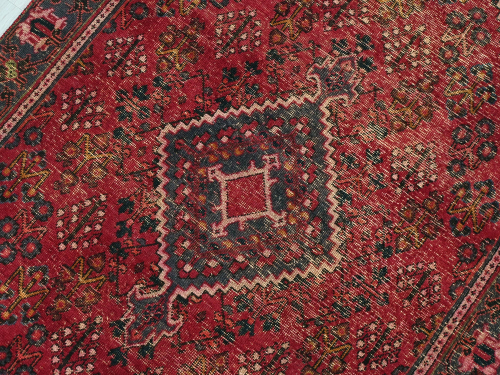 a red oriental rug with an intricate design