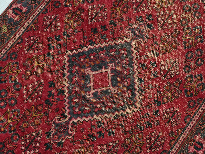 a red oriental rug with an intricate design