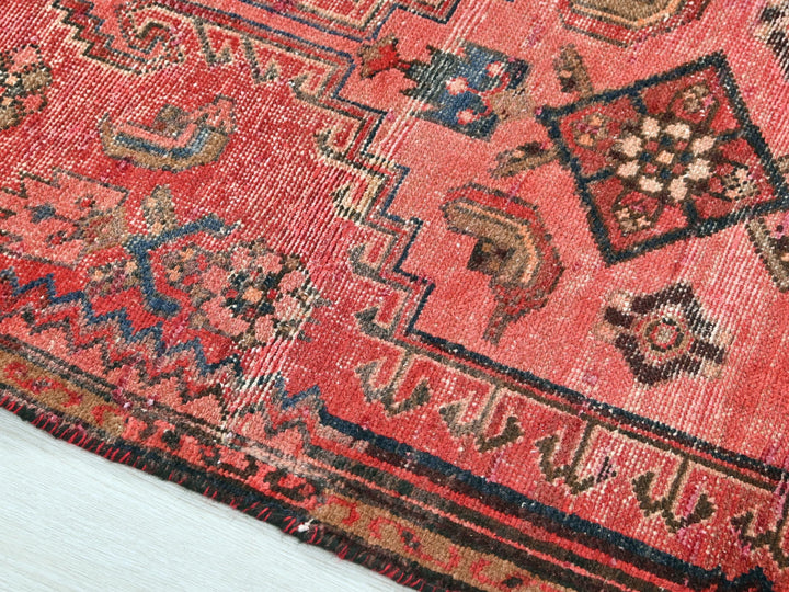 a red rug with a pattern on the middle of it