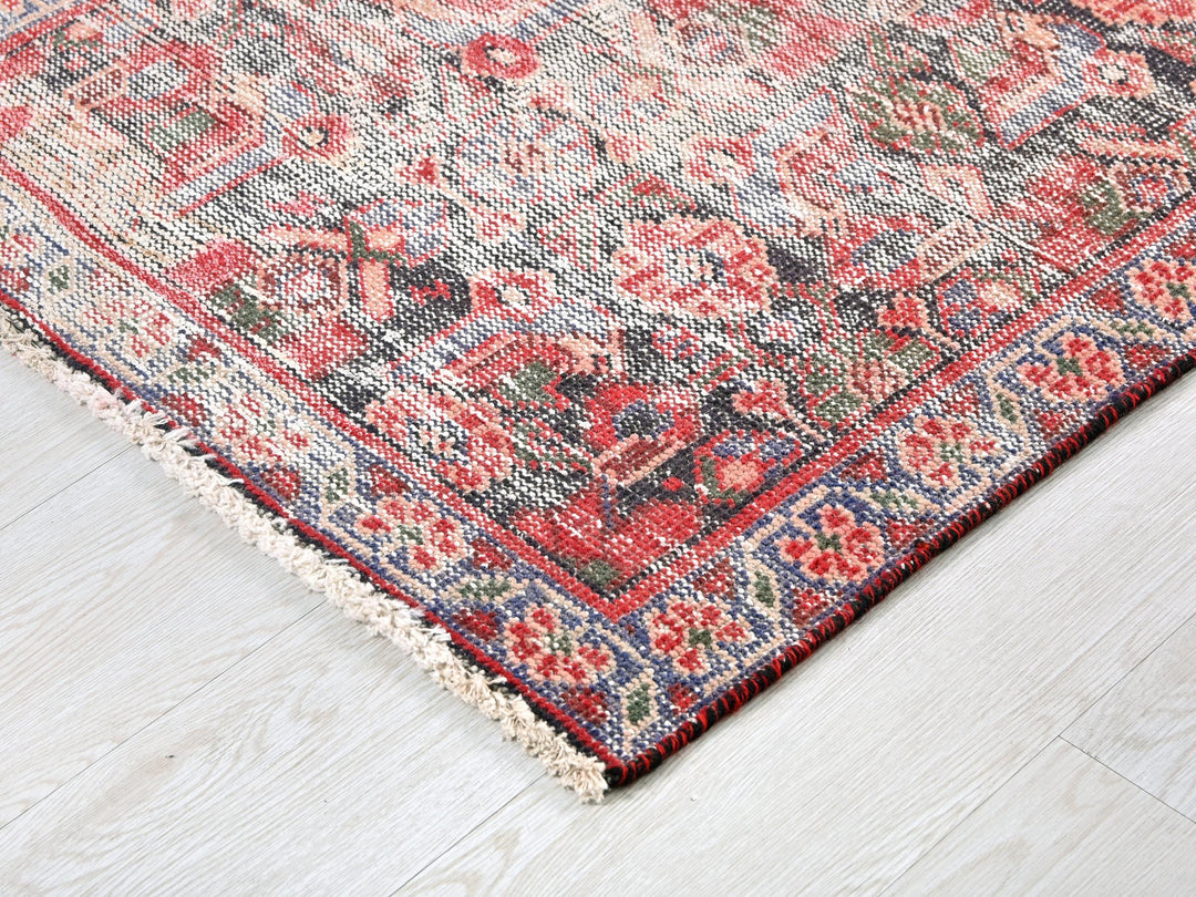 a red and blue rug on a wooden floor