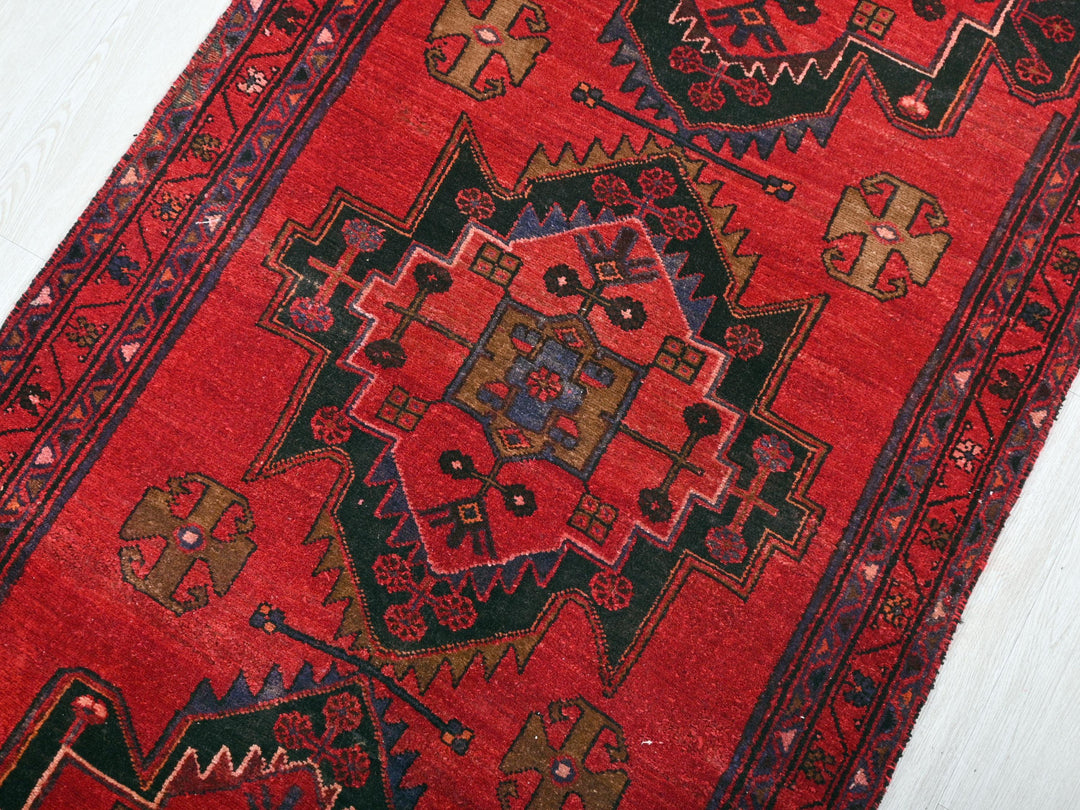 a red rug with a design on the middle of it