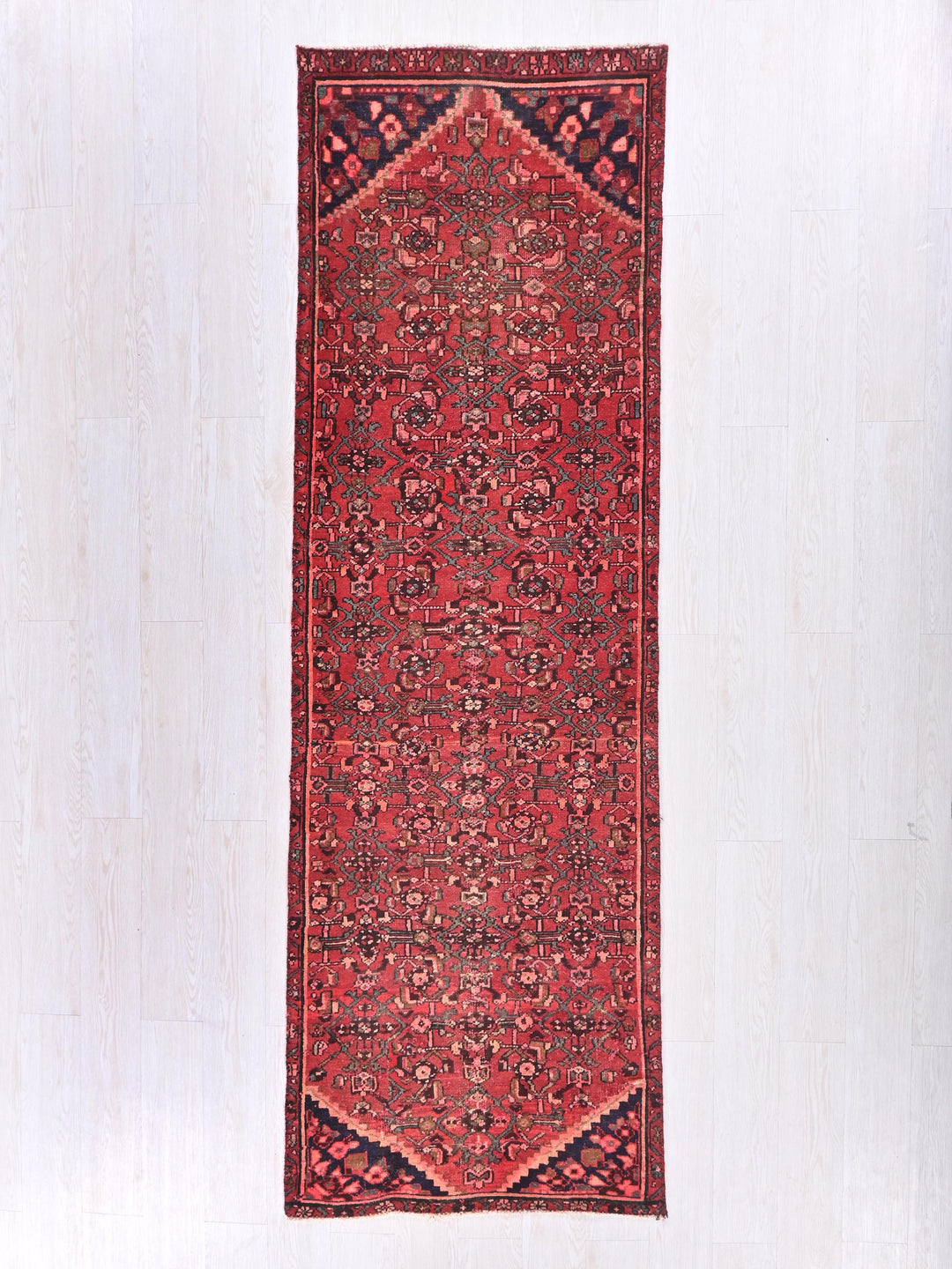 a red oriental rug hanging on a wall