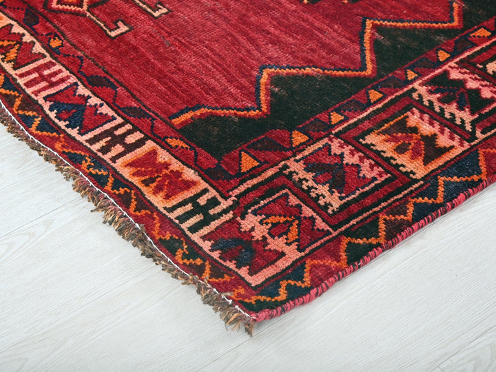 a red rug on a white wooden floor