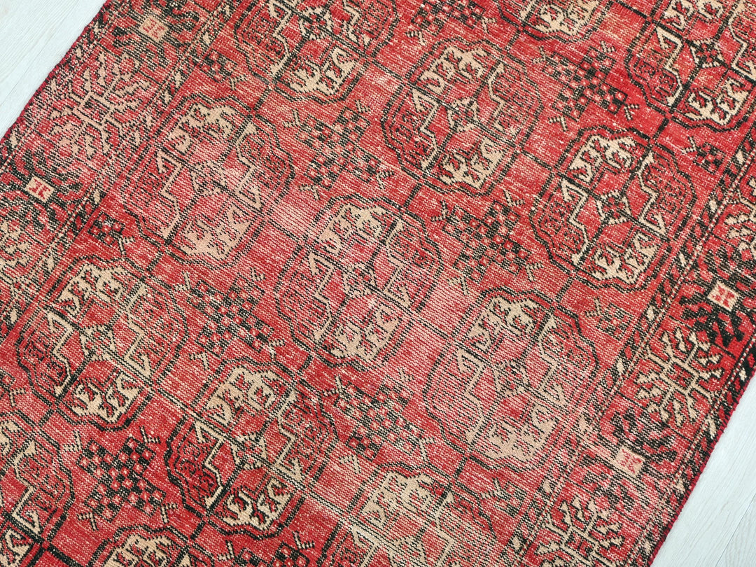 a red and black oriental rug on a wooden floor