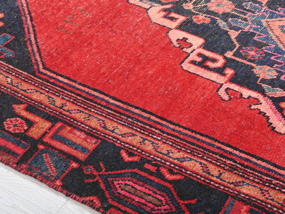 a red rug with a blue and red design on it