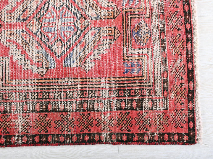 a red and black rug on a white surface