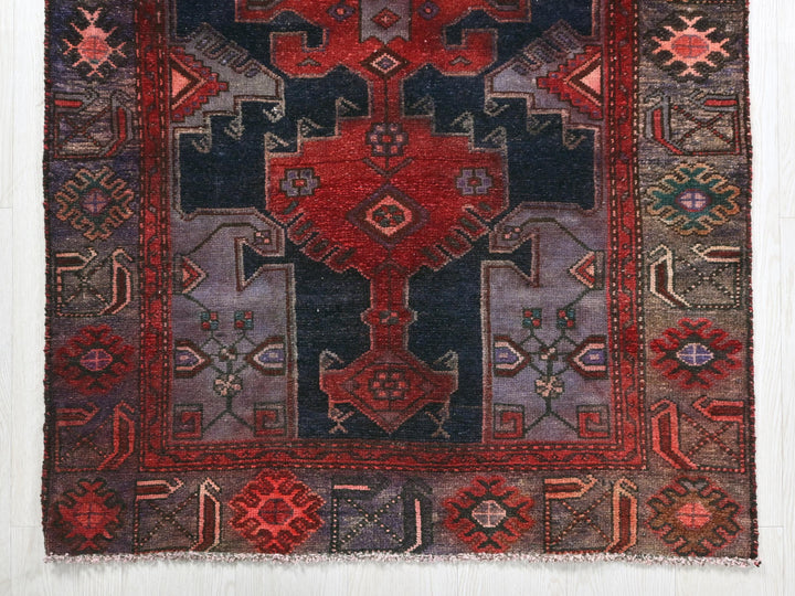a red and blue rug on a white wall